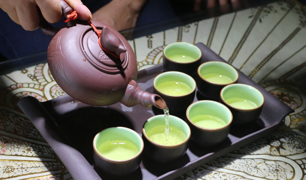 Góc trà chill tĩnh lặng với ấm trà gốm mộc mạc và cuốn sách mở sẵn.